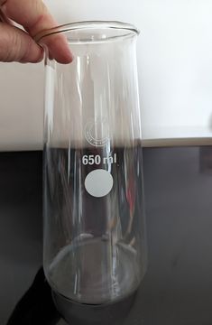 a person is holding a glass with the number 6001 on it