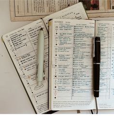 an open notebook and pen sitting on top of each other next to papers with numbers