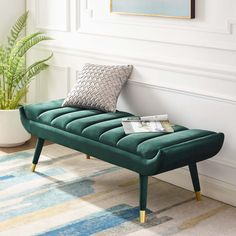 a green bench sitting on top of a rug next to a potted plant