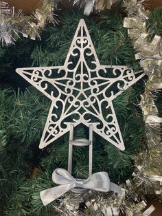 an ornament hanging from a christmas tree in the shape of a star with a bow