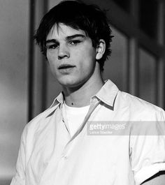 a young man standing in front of a wall