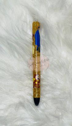 a blue and gold pen sitting on top of a white fur covered floor next to a bottle