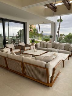 a living room filled with lots of furniture next to large windows and sliding glass doors