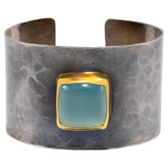 Sterling silver Goddess Cuff, blackened, hammered and distressed featuring a beautiful center Aqua stone set in 22k gold. Hand made, hand textured, one of a kind. Classic and sophisticated with a modern twist. Our goal is to feel powerful, beautiful and confident when wearing these pieces Modern Hammered Cuff Jewelry, Luxury Hammered Cuff Bracelet As Gift, Luxury Hammered Cuff Bracelet, Luxury Hammered Wide Band Jewelry, Silver Goddess, Aqua Stone, Feel Powerful, Gold Hand, 22k Gold