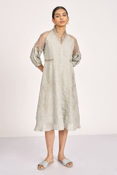 Fern linen A-line dress with poetic interpolation of tribal, floral pattern, attached asymmetric cut, sheer panels and tonal intricate embossed thread embroidery. - Aza Fashions Elegant V-neck Dress With Chikankari Embroidery, Elegant Resham Embroidered Spring Dress, Elegant Dresses With Resham Embroidery For Spring, Elegant Spring Dresses With Resham Embroidery, Chic Embroidered Linen Dress, Elegant Summer Embroidered Dress With Tonal Embroidery, Chic Linen Dresses With Embroidery, Elegant Tunic Dress With Intricate Embroidery, Spring Elegant Kurta With Embroidered Sleeves