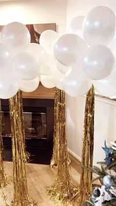 white and gold balloons in front of a fireplace