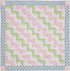 a green and pink quilt on a white background