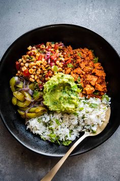 a bowl filled with rice, beans and guacamole