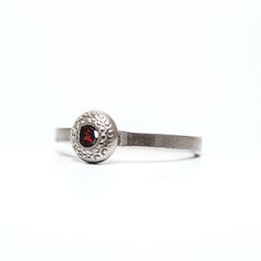 The Silver Garnet Natural Garnet Red Gemstone Button Ring with Texture is a stunning and unique piece of jewelry that combines natural beauty with intricate design. Crafted from high-quality sterling silver, this ring features a natural garnet gemstone that adds a pop of rich, red color to the piece. Size of stone (0.157'')4 mm. Width of ring (0.0787) 2nmm. 🎁🎁SENT IN A GIFT BOX READY🎁🎁 For any question please contact me. The ring can be customized with other gemstones upon your request. This Red Gemstone Ring, Garnet Ring Silver, January Birthstone Rings, Judaica Jewelry, Ring Birthstone, Red Gemstones, Button Ring, Square Rings, Garnet Ring