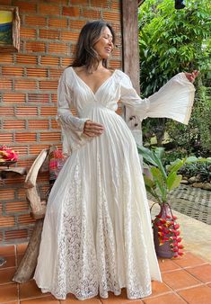 a woman in a white dress standing on a porch