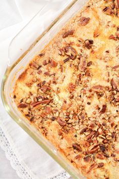 a casserole dish with pecans in it on a white table cloth and napkin