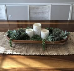 a tray with candles and succulents on it