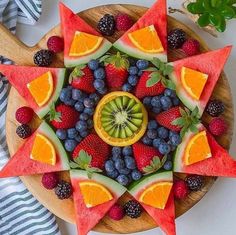 an arrangement of fruits arranged in the shape of a star on a wooden platter