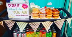 a table with donuts, sodas and doughnuts for sale on it