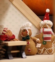 three gingerbread men sitting next to each other in front of a piece of wood