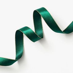 a green satin ribbon is on a white surface and there are no other ribbons in the photo