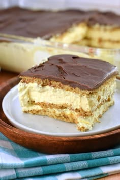 a piece of cake sitting on top of a white plate next to a glass dish