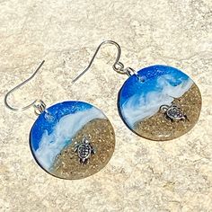 "These realistic beach earrings are made with iridescent layers of resin, bright colorful inks and real sand with a 3D silver turtle crawling in the sand. These earrings are 1\" diameter. I make my own molds and each set is handmade so you won't find these anywhere else. These are made to order and yours may be slightly different than those pictured." Handmade Sand-colored Ocean-inspired Jewelry, Handmade Ocean-inspired Sand Colored Jewelry, Unique Nickel-free Earrings For Beach, Resin Drop Earrings For Beach, Resin Dangle Earrings For Beach, Resin Earrings For Summer Beach, Summer Beach Resin Earrings, Blue Resin Earrings For Beach, Blue Resin Earrings For The Beach