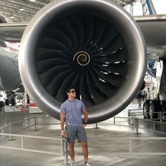 a man standing in front of an airplane engine