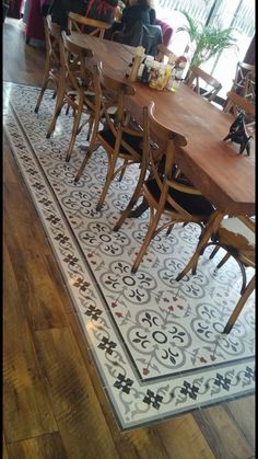 a dining room table with chairs and a rug on the floor