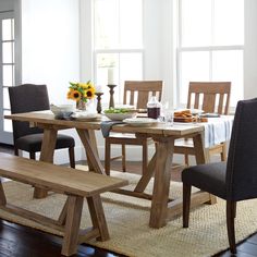 a dining room table with two benches in front of it