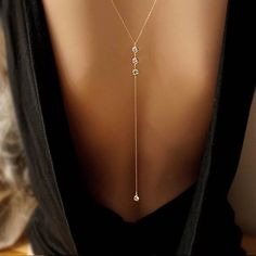 the back of a woman's neck wearing a necklace