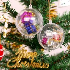 two ornaments hanging from a christmas tree decorated with gold, red and blue presents on them