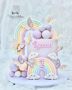 a birthday cake decorated with pastel colors and butterflies