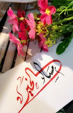 flowers are sitting on top of a piece of paper next to a sign that says love