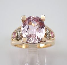 14K Yellow Gold Diamond, Pink Sapphire and Kunzite Ring. This ring is set in the center with one genuine Oval Kunzite. This Kunzite measures 12 X 10 mm and weighs 3 1/2 carat.  There are two Round Pink Sapphires bezel set in this ring, these gemstone weigh a total of .30 carat.  There are also twelve genuine Round Brilliant Diamonds set in the ring. These diamonds are H color, SI/I clarity and weigh a total of .08 carat. This ring is 14KT Yellow Gold, weighs 9.0 grams and is a finger size 7, which can be resized (please inquire about sizing with the finger size you need). This ring will be accompanied by an appraisal written by a GIA Certified Diamond Grader with the retail replacement value of $3,695.00. I will ship this ring promptly in a beautiful gift box. ADDITIONAL REQUESTS If you wo Morganite Multi-stone Anniversary Rings, Morganite Multi-stone Rings For Anniversary, Morganite Multi-stone Jewelry For Anniversary, Morganite Multi-stone Jewelry For Anniversaries, Kunzite Ring, Saphir Ring, Pink Sapphire Ring, Engagement Ring Sizes, Diamond Settings