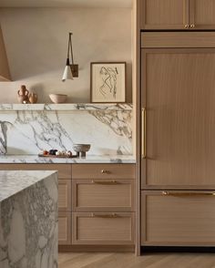 a kitchen with marble counter tops and wooden cabinets