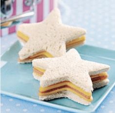 two small sandwiches on a blue plate with a pink and white polka dot tablecloth