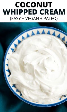 a bowl filled with whipped cream on top of a blue cloth next to a spoon