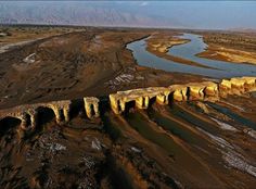 an aerial view of a river and bridge in the desert