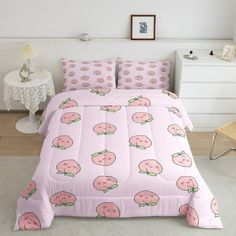 a bed covered in pink bedspread with strawberrys on it