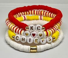 Set of 4 hand beaded bracelets with gold accents and lettering. Each bracelet is made with 6mm Heishi beads. Customization available. Kc Chiefs Birthday Party, Buffalo Bills Clay Bead Bracelet, School Spirit Beaded Bracelet With Letter Beads As Gift, Chiefs Clay Bead Bracelet, School Spirit Beaded Bracelets With Letter Beads For Gifts, Chiefs Game Day Outfit, Football Team Clay Bead Bracelets, Chiefs Heishi Bracelet, Kc Chiefs Clay Bead Bracelet