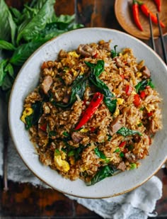 a white plate topped with fried rice and veggies next to some chopsticks