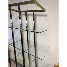 a glass and metal shelf on the wall