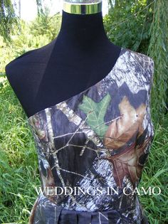 the back of a camo wedding dress on display in front of some tall grass