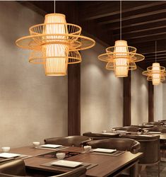 an empty restaurant with wooden tables and brown chairs, lights hanging from the ceiling above them