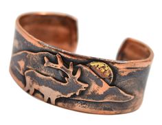 PRICES MAY VARY. Durable unisex cuff bracelet is crafted using reclaimed pure copper 1-inch-wide cuff is enhanced with an elk and mountain motif Rustic patina highlights the elk design and emphasizes the organic characteristic of copper Available in adjustable medium and large sizes (see description below for sizing detail) Artisan-crafted in the USA Adorned with an elk and mountain design, this copper cuff bracelet is individually handcrafted using rustic reclaimed copper. The cuff is provided Hammered Copper Jewelry, Copper Properties, Copper Uses, Mountain Design, Soldering Jewelry, Copper Cuff Bracelet, Cuff Jewelry, Copper Cuff, Native Jewelry