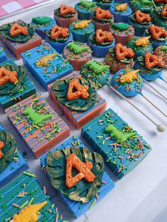 many cupcakes are arranged on a table with sticks in the shape of letters