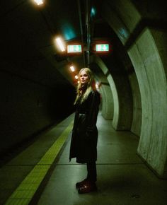 a woman standing in a tunnel talking on her cell phone