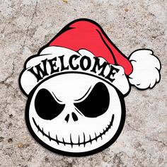 a sticker that says welcome with a skull wearing a santa's hat on it