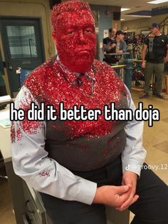 a man with red paint on his face sitting down