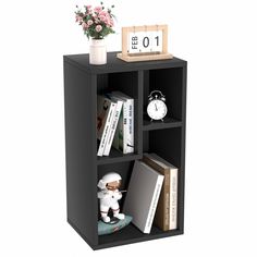 a book shelf with books, an alarm clock and flowers on it in front of a white background