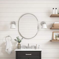 a bathroom vanity with a round mirror above it and shelving on the wall behind it