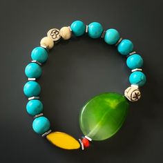 The Green Agate Summer Vibe Bracelet is a stunning accessory that exudes a sense of energy and vitality. The Green Agate stone is said to promote balance and harmony, while the other stones and beads are thought to have their own unique energy properties as well.The bracelet also features a vibrant yellow African bead, which is said to symbolize happiness and prosperity. Together, these elements create a beautiful and vibrant piece that is perfect for adding a touch of color to any summer outfit Agate Natural Stone Bracelets For Meditation, Agate Bracelets With Natural Stones For Meditation, Handmade Jade Bracelets For Meditation, Holistic Turquoise Beaded Bracelets With Natural Stones, Agate Bracelets With Polished Beads For Meditation, Jade Stretch Bracelet For Meditation With Natural Stones, Turquoise Agate Bracelet, Jade Stretch Bracelet With Natural Stones For Meditation, Blue Jade Bracelets For Healing