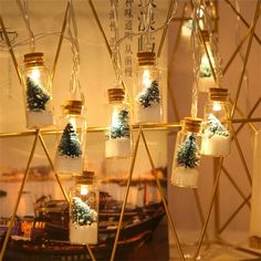 there are many glass jars with lights in them hanging from the ceiling and decorated with snowflakes