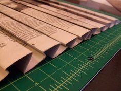 several pieces of paper sitting on top of a green cutting board next to a ruler